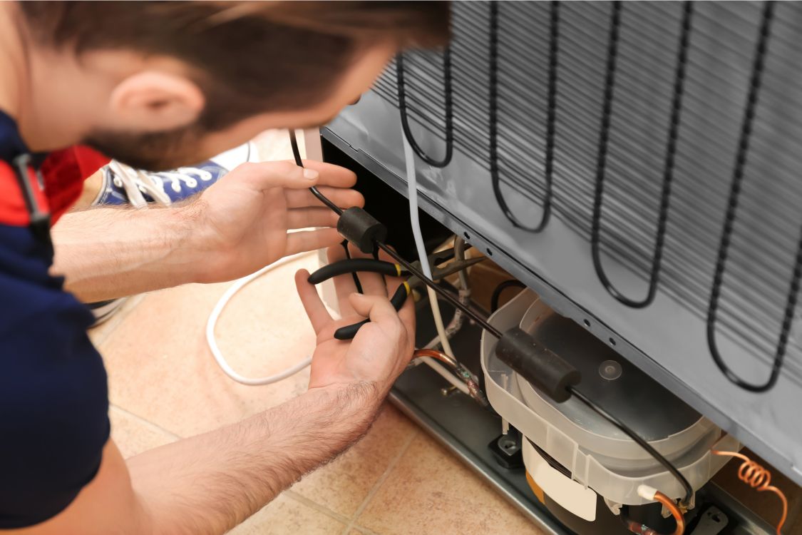 Technician repairing refrigerator coils